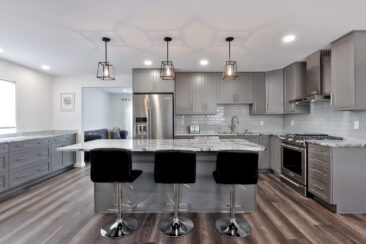 Photo of home renovations - a newly renovated kitchen in an Edmonton area home with marble countertops, stainless steel appliances and new cabinets