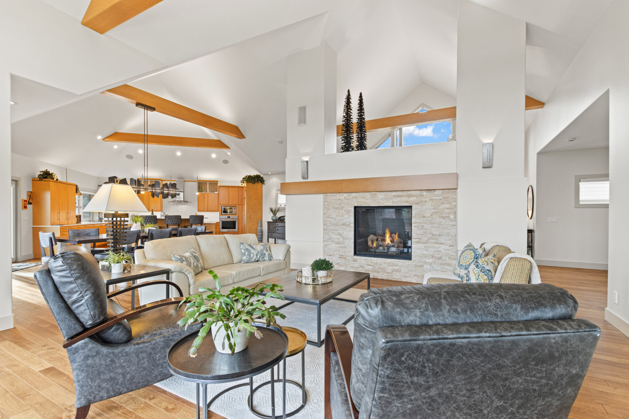 A cozy living room featuring a fireplace, seamlessly connected to a modern kitchen area.