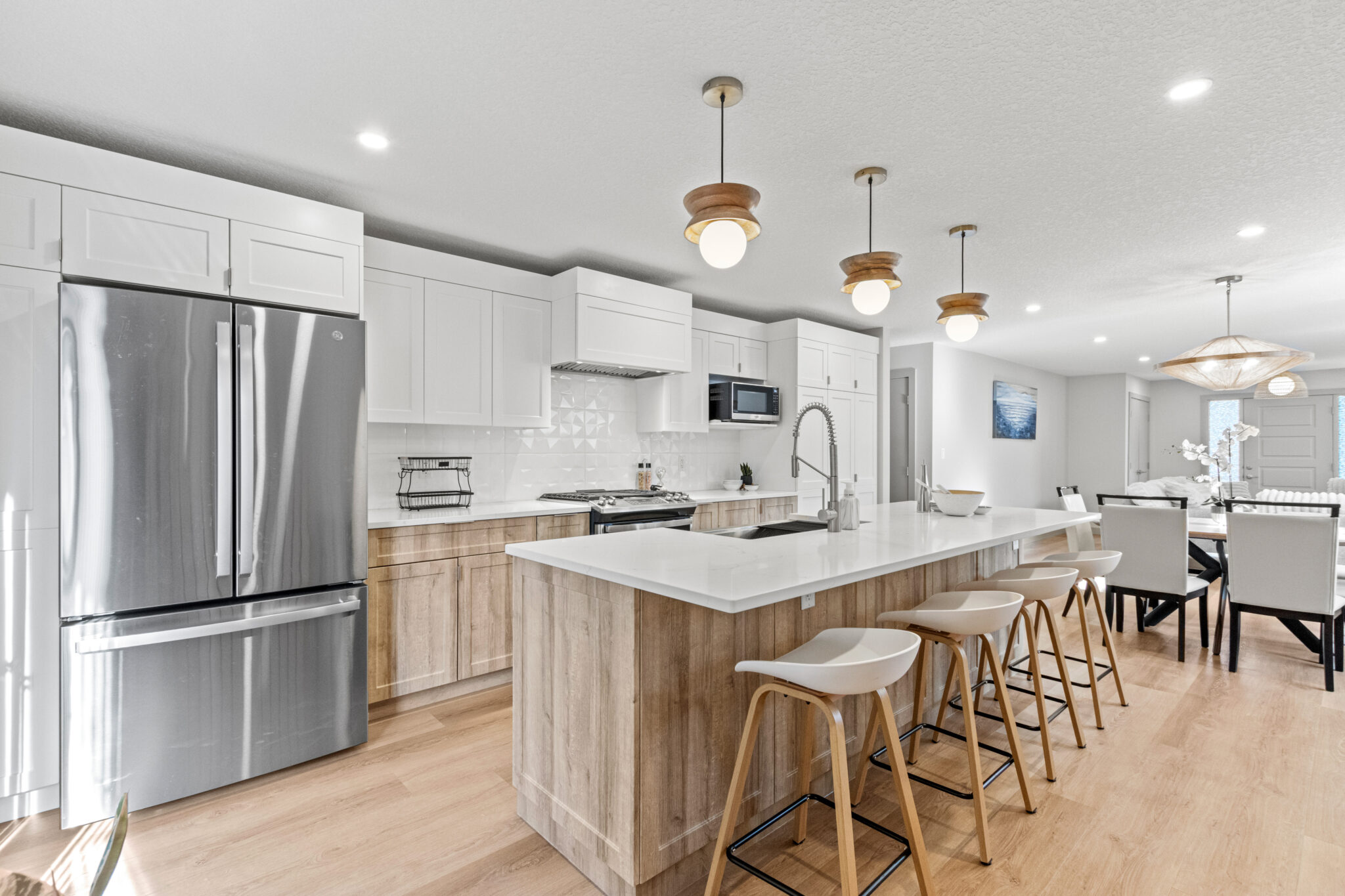 Bright kitchen with white cabinetry and contemporary stainless steel appliances.